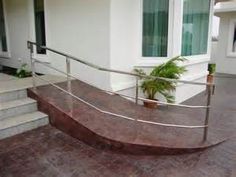 a metal hand rail on the outside of a house with potted plant in front