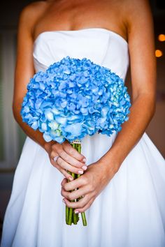 a bride holding a bouquet of blue flowers