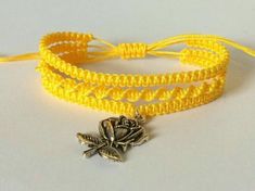 two yellow bracelets with silver charms on them