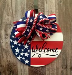 an american flag welcome sign hanging on a wooden wall