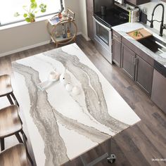 a modern kitchen with marble counter tops and stainless steel appliances