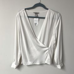 Pretty Off-White Wrap Blouse. It Ties On The Inside And Then Buttons On The Outside. Would Look Cute In The Summer With A Pair Of Jeans. New With Tags. Would Best Fit A Medium, See Measurements Below. Measurements (Laid Flat) Waist: Approx 18 In. (When Buttoned Closed) Pit To Pit: 19.4 (When Buttoned Closed) Length: 24 In Tag Size: Medium White Long Sleeve Top From H&m, H&m White Long Sleeve Top, H&m V-neck Tops For Day Out, H&m Summer Tops For Work, H&m Summer Workwear Tops, H&m V-neck Blouse For Summer, H&m V-neck Summer Blouse, White Long Sleeve Shirt From H&m, H&m Long Sleeve Tops For Work