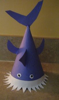 a blue and white paper hat with spikes on the top, sitting on a table