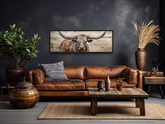 a living room with leather couches and potted plants on the side table in front of it