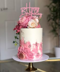 a white and pink cake with flowers on top