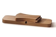 three pieces of wood sitting on top of each other in front of a white background