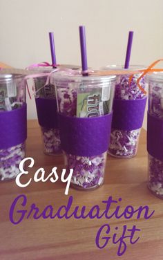 four cups filled with purple and white confetti sitting on top of a wooden table