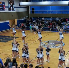 a group of cheerleaders standing on top of a basketball court