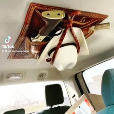 there is a cow head hanging from the ceiling in this car with other items on it