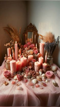 a table topped with lots of candles next to a vase filled with flowers and seashells