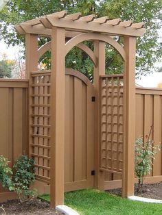 a wooden gate in the middle of a yard