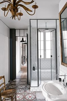 a bathroom with a chandelier hanging from the ceiling next to a bathtub