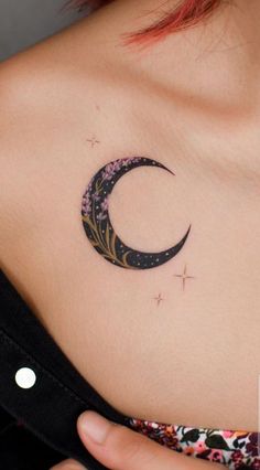 a woman's chest with a crescent tattoo on it and stars in the sky