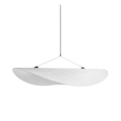 a white light hanging from a black wire on a white wall with an oval shape