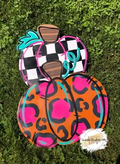 three painted pumpkins sitting in the grass