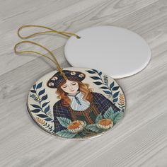 a ceramic ornament with a woman's face painted on the front and side