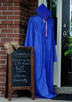 a graduation gown and cap are on display in front of a door with a chalkboard