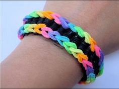 a person wearing a rainbow bracelet on their arm with the colors of the rainbow and black