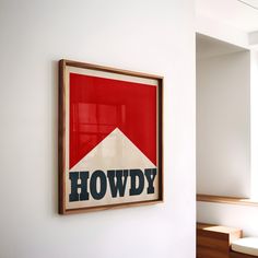 a red, white and blue poster hanging on the wall next to some stairs in a room