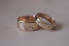 two gold wedding rings with stars on them