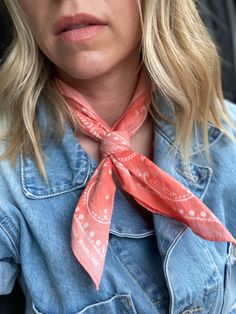 a woman wearing a pink bandana and denim jacket