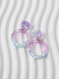 Circle shaped dangle earrings in translucent lilac purple, with colour shifting iridescent glitters in ice blue and pink tones. These are perfect for adding a pop of colour and sparkle to any outfit, and make a geometric statement wherever you go. These earrings would make a stunning gift for any pastel lover or a special treat just for you! ⚒️ These are made from resin, iridescent glitters and are attached to stainless steel hypoallergenic stud posts with butterfly backs. They measure 41 mm x 2 Clear Pierced Jewelry For Party, Trendy Iridescent Jewelry For Gifts, Glitter Party Jewelry, Lavender Drop Earrings For Party, Pink Glitter Drop Earrings, Purple Round Hoop Earrings For Gift, Purple Round Hoop Earrings As Gift, Resin Jewelry With Matching Earrings For Party, Elegant Glitter Dangle Jewelry