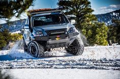 an off road vehicle driving through the snow