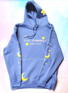 Introducing the Keep Dreaming Pullover Hoodie - the essential wardrobe staple for all Soft Girls out there looking to let their dreams take flight. With moon and star details on the arms and hood, you can stay cozy, comfy, and dreamy while you chase your wildest fantasies! 🌙☁️🌠 This is *not* a POD product, I am pressing these myself so stock is limited to what blanks I have on hand.  Hoodie itself is mid-weight and a natural fit, runs just slightly small. For an oversized/baggy look, please size up! There is very little shrinkage after washing. Graphics are DTF Transfers and hold up really well over time. Blue Harajuku Cotton Sweatshirt, Blue Cotton Kawaii Hoodie, Blue Cotton Harajuku Sweatshirt, Kawaii Blue Cotton Hoodie, Blue Long Sleeve Kawaii Sweatshirt, Cute Blue Crew Neck Hoodie, Blue 90s Crew Neck Hoodie, 90s Blue Crew Neck Hoodie, 90s Blue Cotton Hoodie