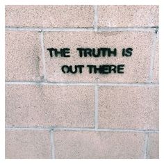 graffiti on the side of a brick wall that says, the truth is out there