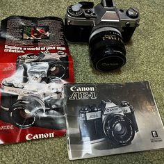 three different cameras sitting on top of a carpeted floor next to an open magazine