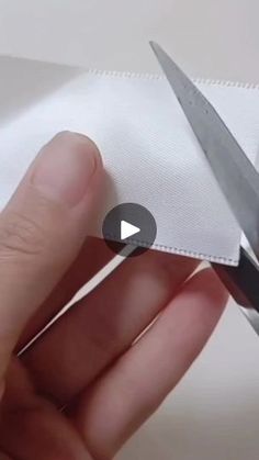 someone cutting fabric with scissors on top of it