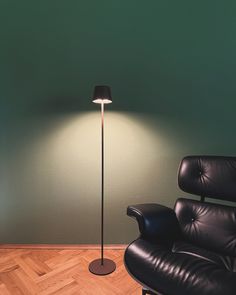 a black chair and lamp in a room