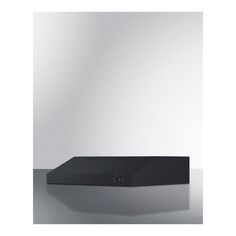 a black box sitting on top of a table next to a white wall and floor