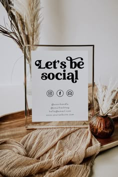 there is a sign that says let's be social next to some dried plants