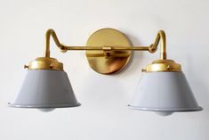 two lights are attached to the wall with one light on it's side, while the other is off