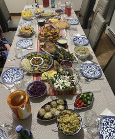 a long table covered in plates and bowls filled with food