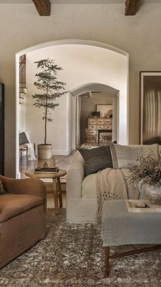 a living room filled with furniture and a painting on the wall above it's doorway