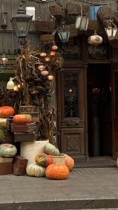 pumpkins and gourds are piled up in front of a store