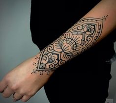 a woman's arm with a tattoo on it that has an intricate design in the middle