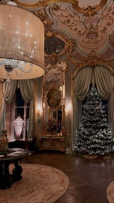 a living room with a christmas tree in the center and chandelier hanging from the ceiling