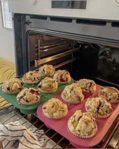 muffins sitting on trays in front of an oven