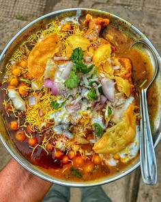 a person holding a metal bowl filled with food