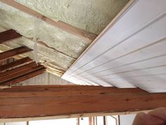 an unfinished ceiling with wood beams and white paint