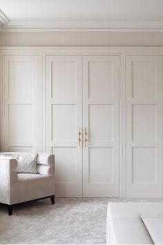 an empty room with white furniture and large closets on the wall, along with a couch