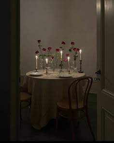 the table is set with candles and flowers in vases on top of each other