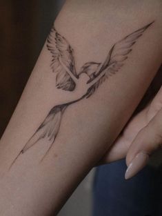 a woman's arm with a bird tattoo on it