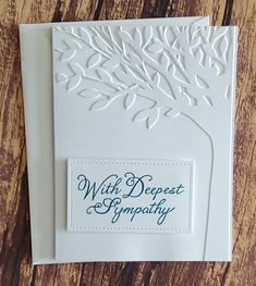 a close up of a greeting card on a wooden surface with the words witt deepest sympathy