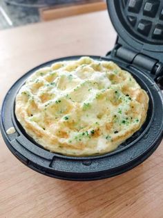 a close up of a waffle maker on a table with some food in it