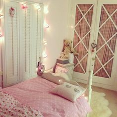 a bedroom decorated in pink and white with teddy bears