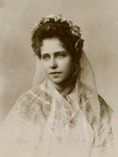 an old black and white photo of a woman wearing a veil